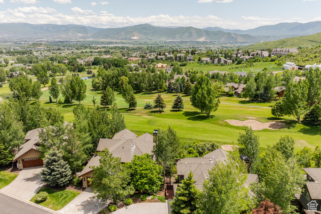 Aerial view of residential area featuring a mountain backdrop and a local golf course