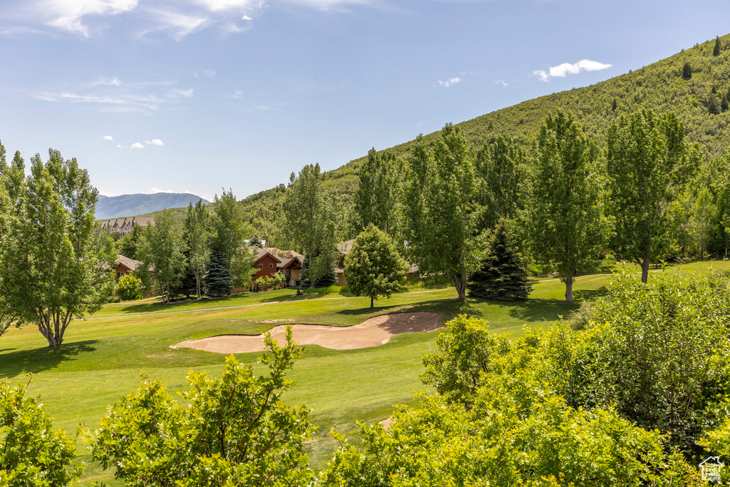 View of home's community featuring a mountain view, a yard, and view of golf course