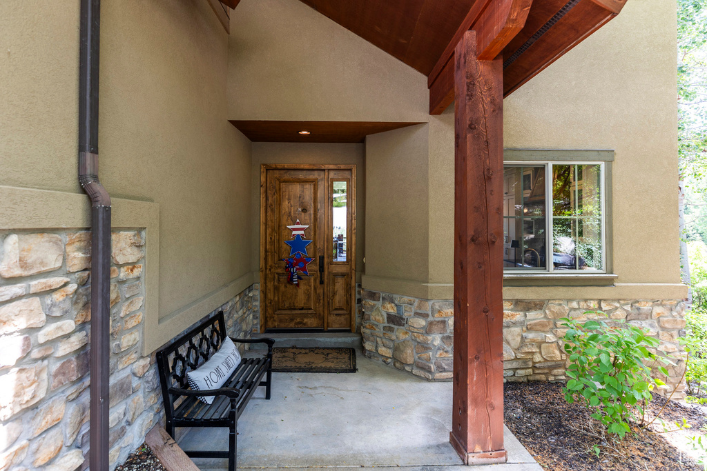 View of exterior entry with stone siding and stucco siding