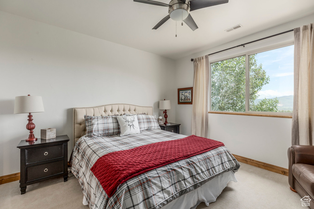 Bedroom featuring light colored carpet and a ceiling fan