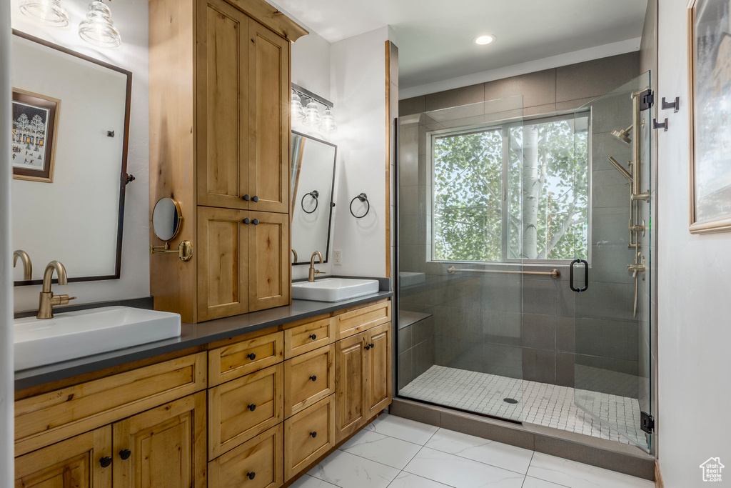 Bathroom with double vanity, a stall shower, and recessed lighting