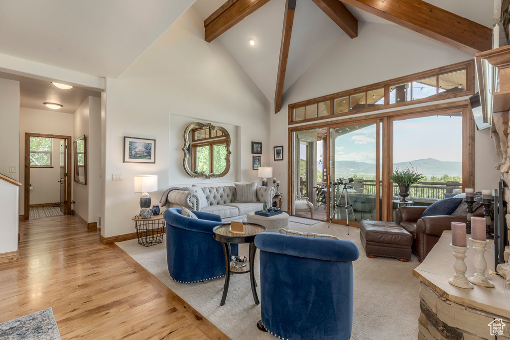 Living area featuring light wood-style flooring, beam ceiling, high vaulted ceiling, and a mountain view