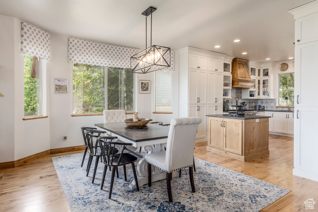 Dining space featuring light wood-style flooring, recessed lighting, and a chandelier