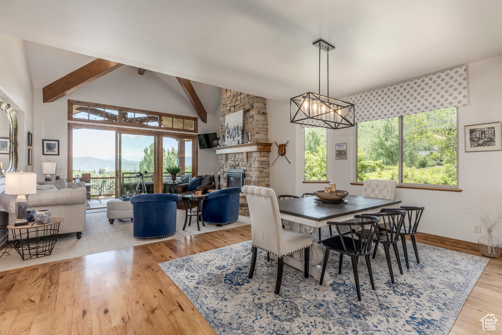 Dining area featuring a fireplace, healthy amount of natural light, a chandelier, and wood finished floors