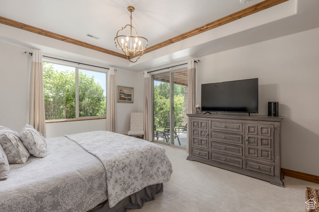 Bedroom featuring access to outside, a chandelier, light colored carpet, a raised ceiling, and ornamental molding