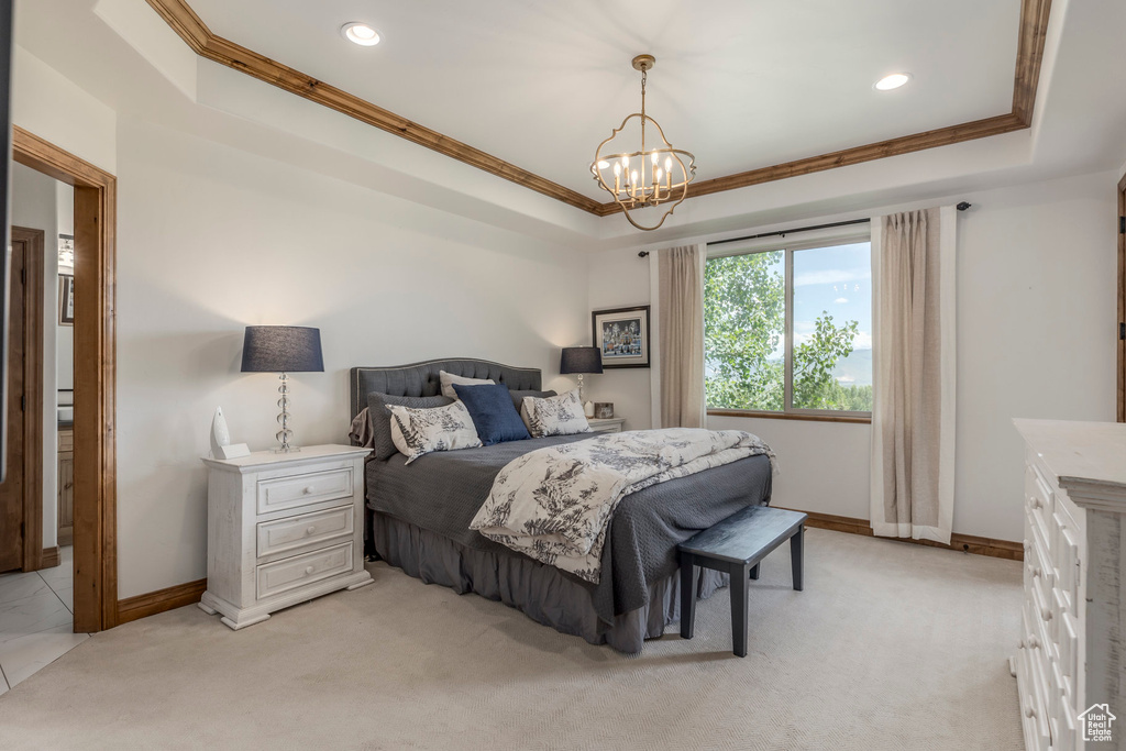 Bedroom featuring a tray ceiling, crown molding, a chandelier, light colored carpet, and recessed lighting