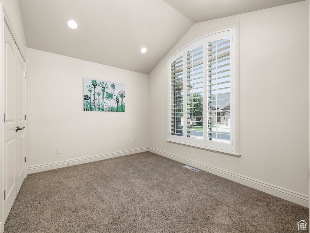 Spare room featuring lofted ceiling, carpet floors, and recessed lighting