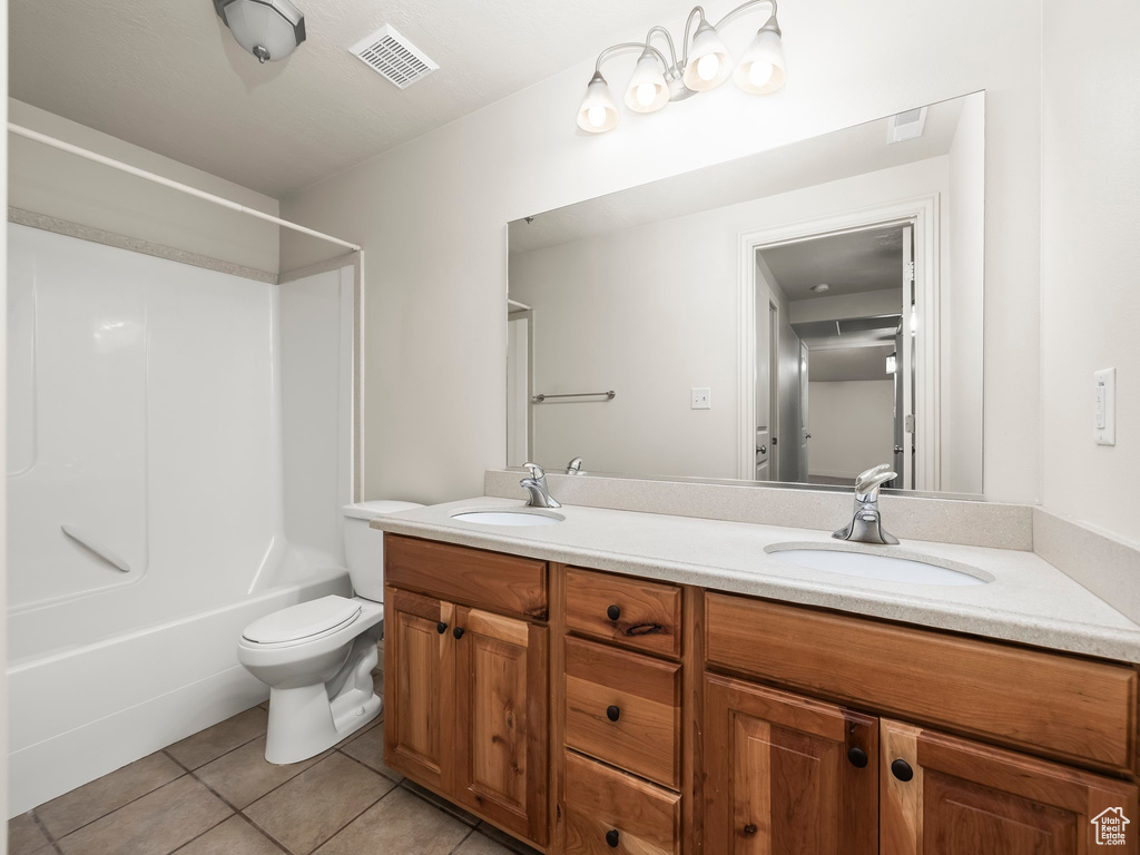 Full bathroom with double vanity, tile patterned flooring, and shower / tub combination