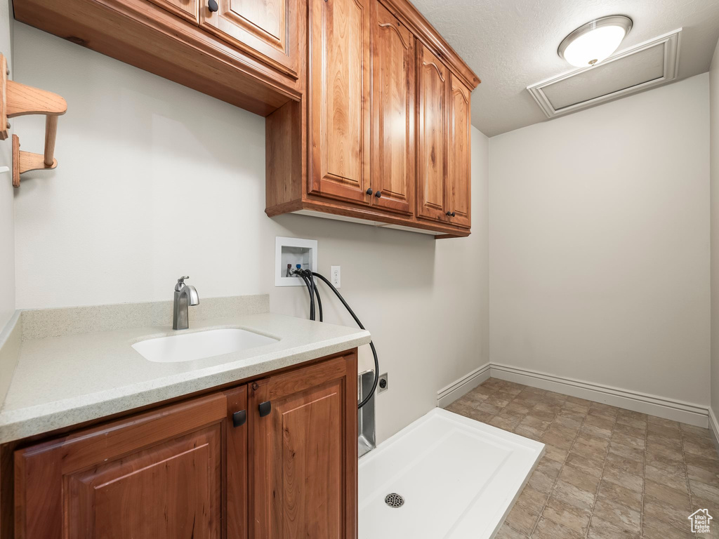 Laundry area with electric dryer hookup, cabinet space, hookup for a washing machine, and attic access