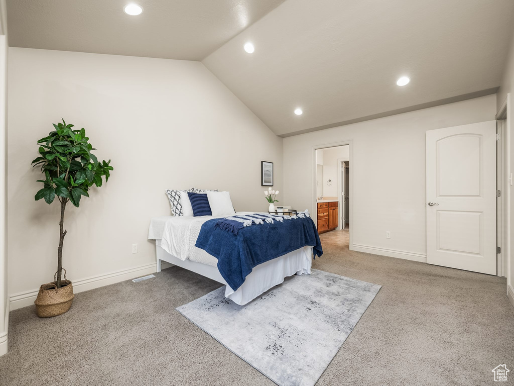 Carpeted bedroom with recessed lighting, lofted ceiling, and ensuite bath