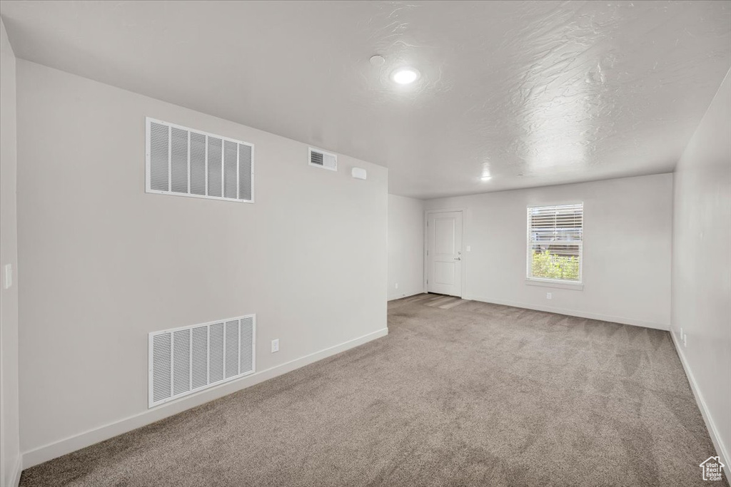 Unfurnished room with carpet and a textured ceiling