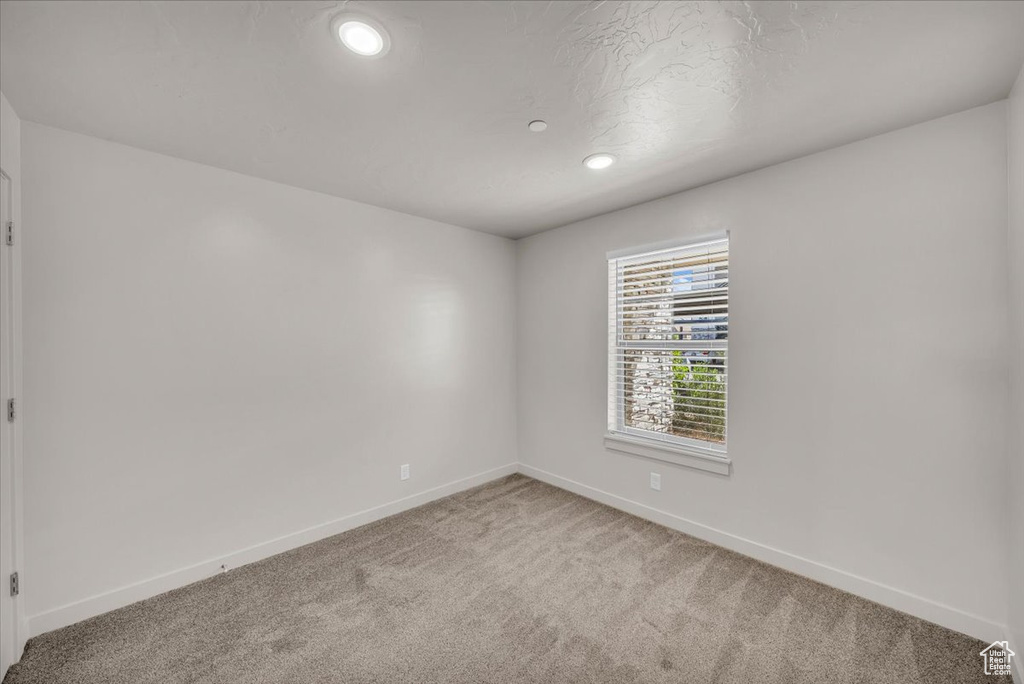 Unfurnished room with light colored carpet and recessed lighting