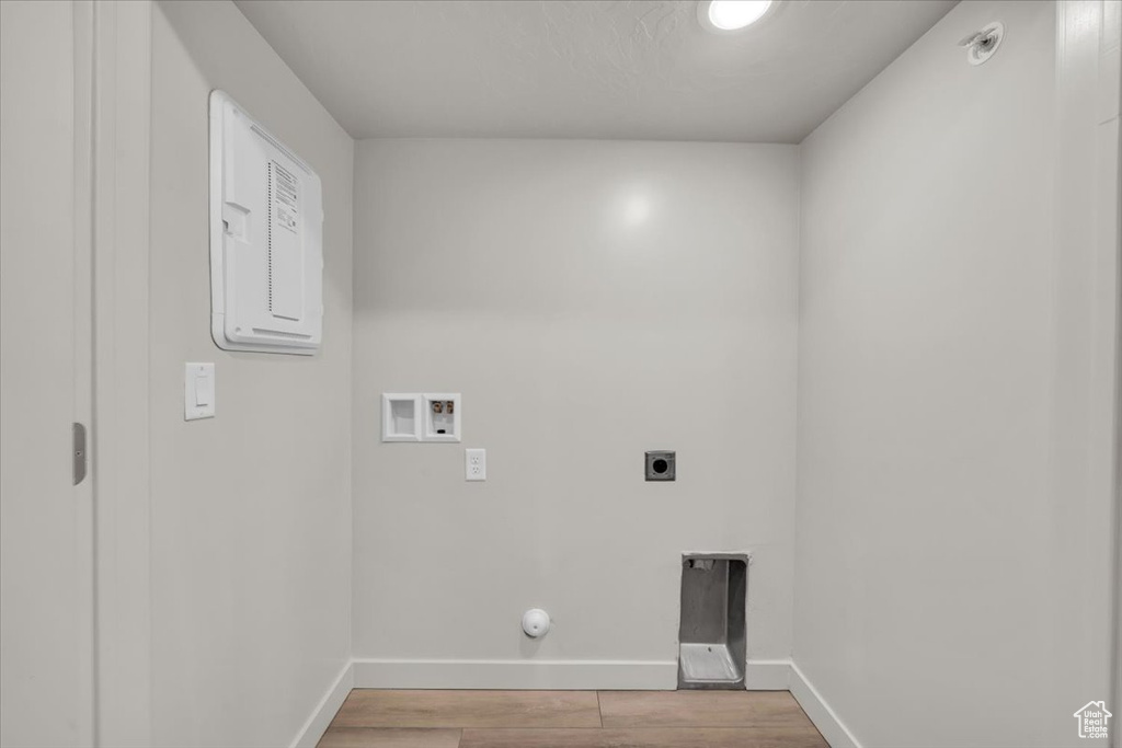 Laundry room with hookup for a washing machine, hookup for an electric dryer, light wood-type flooring, electric panel, and hookup for a gas dryer