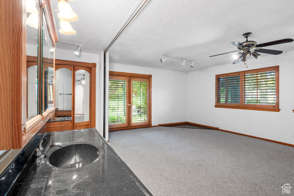 Carpeted entrance foyer featuring french doors, rail lighting, and a ceiling fan