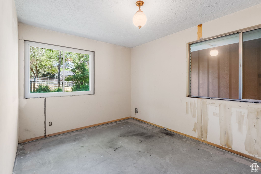 Spare room featuring unfinished concrete flooring and a textured ceiling