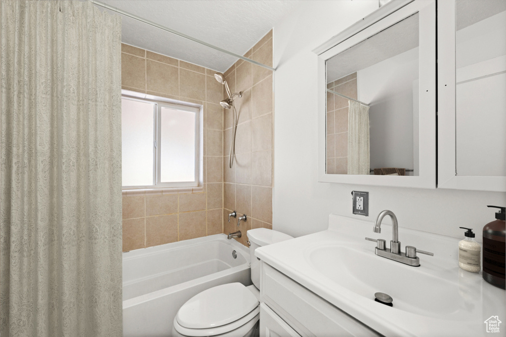 Bathroom featuring shower / bath combination with curtain and vanity