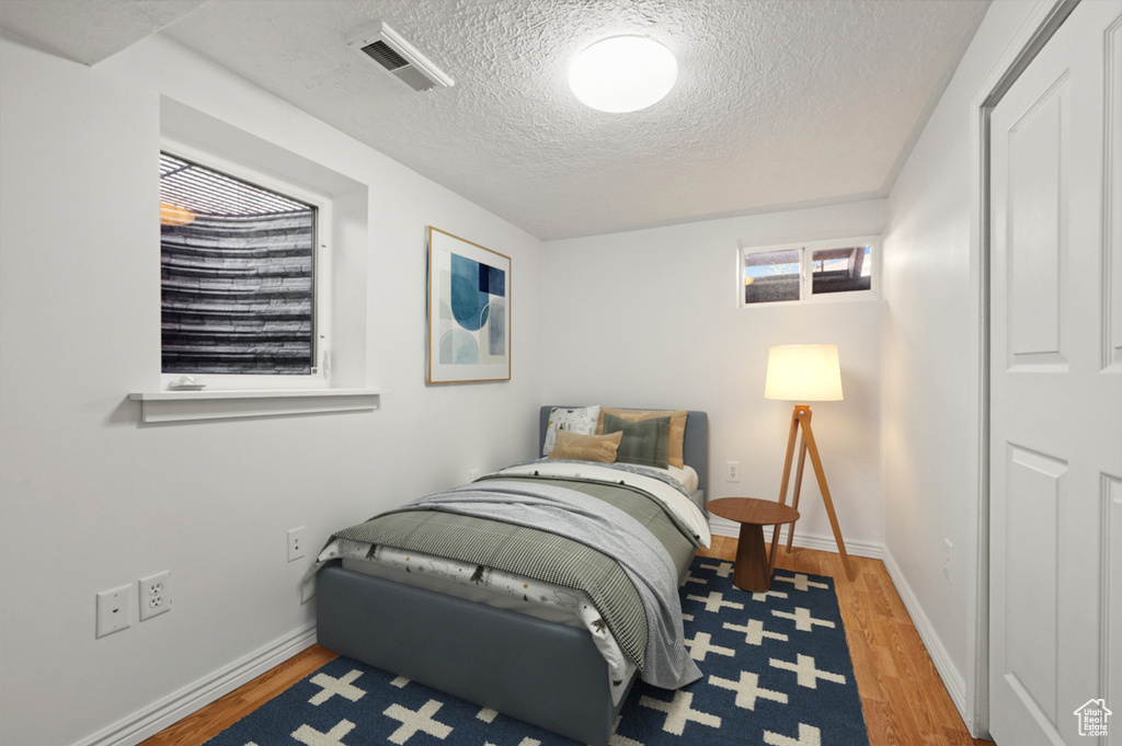 Bedroom featuring wood finished floors and a textured ceiling