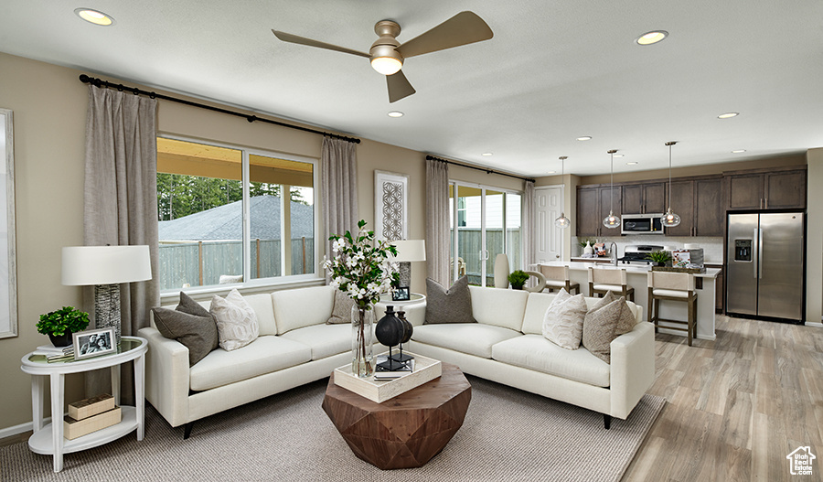 Living area featuring ceiling fan, light wood-style floors, and recessed lighting