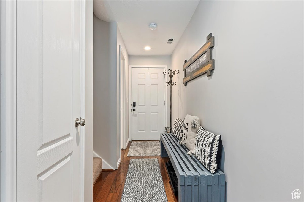 Doorway with dark wood finished floors, baseboards, and recessed lighting
