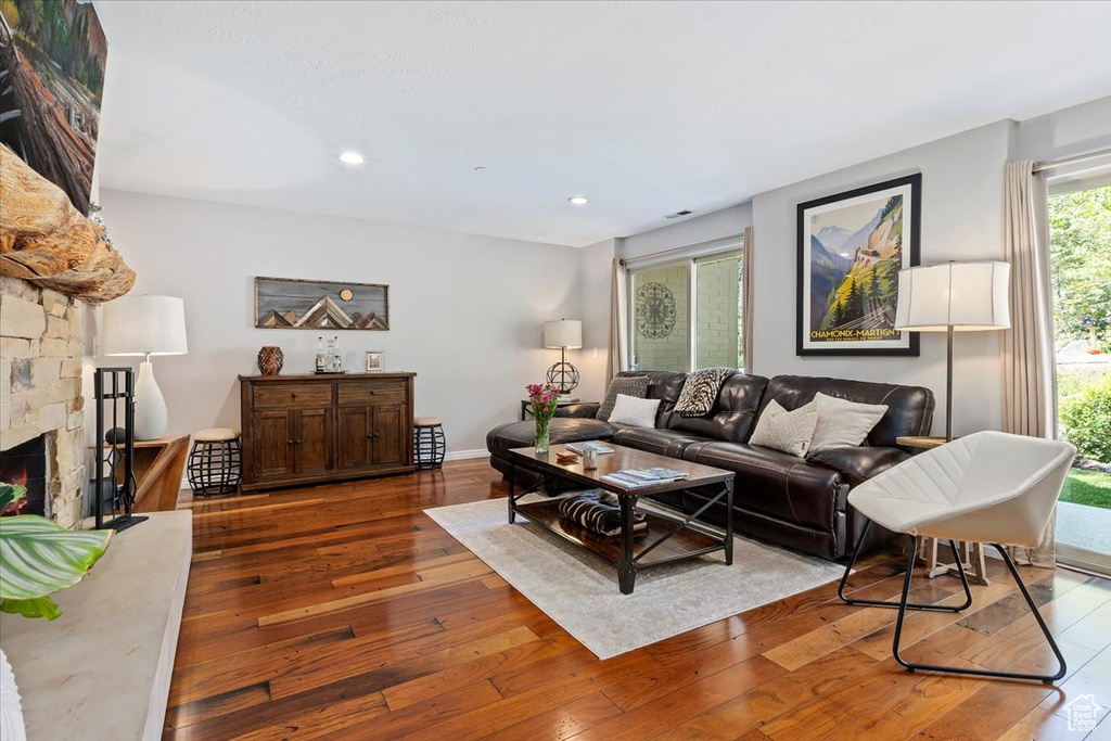 Living area with hardwood / wood-style flooring, a fireplace, recessed lighting, and baseboards