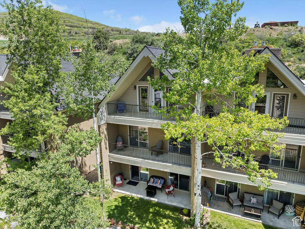 Rear view of house with outdoor lounge area, a patio, and a balcony