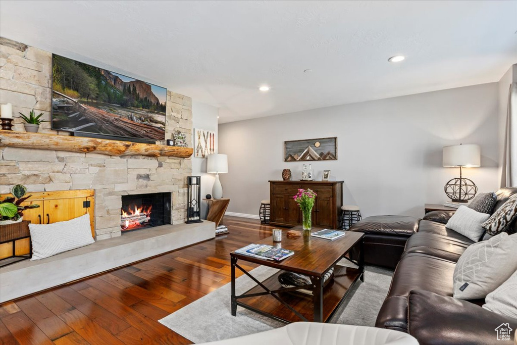 Living room with a fireplace, hardwood / wood-style flooring, baseboards, and recessed lighting