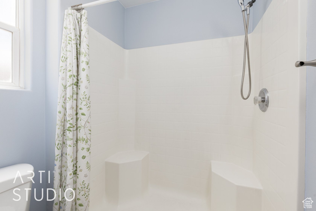 Full bathroom with a tile shower and toilet