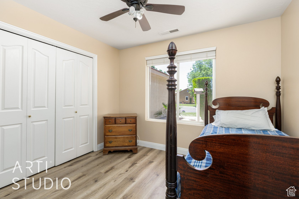Bedroom with light wood-style flooring, a closet, baseboards, and ceiling fan