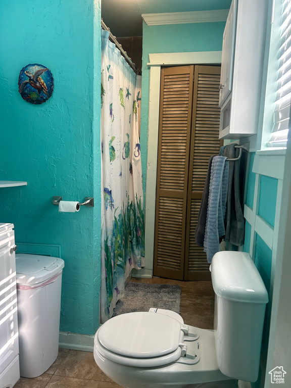 Full bathroom with ornamental molding, a closet, a textured wall, and curtained shower