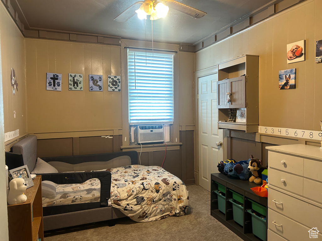 Carpeted bedroom with cooling unit and a ceiling fan