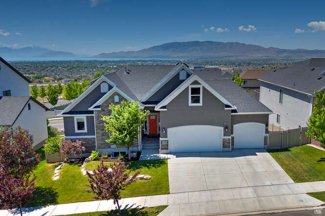 Craftsman-style house featuring stone siding, a mountain view, concrete driveway, and a garage