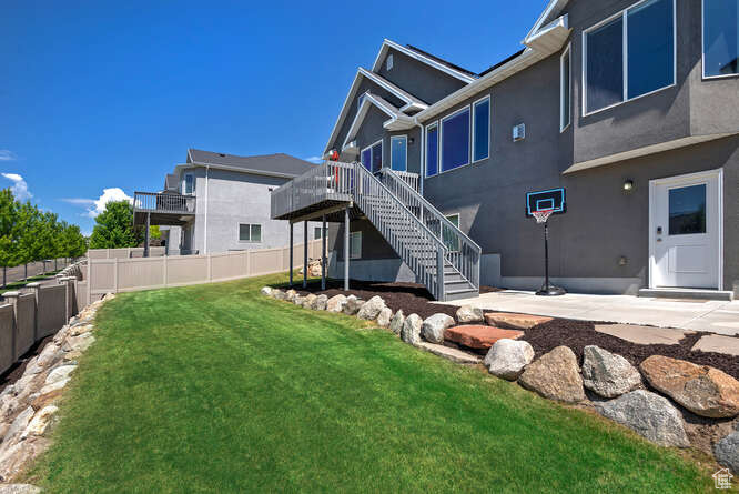 Back of house with stairs, stucco siding, and a wooden deck