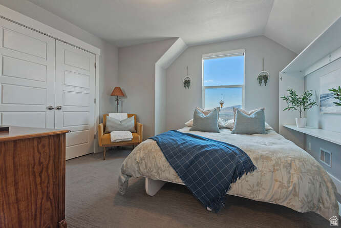 Carpeted bedroom with lofted ceiling