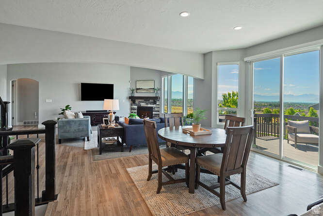 Dining space featuring a fireplace, wood finished floors, arched walkways, and recessed lighting