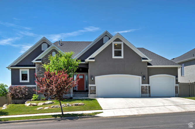 Craftsman-style home with stone siding, stucco siding, concrete driveway, and an attached garage