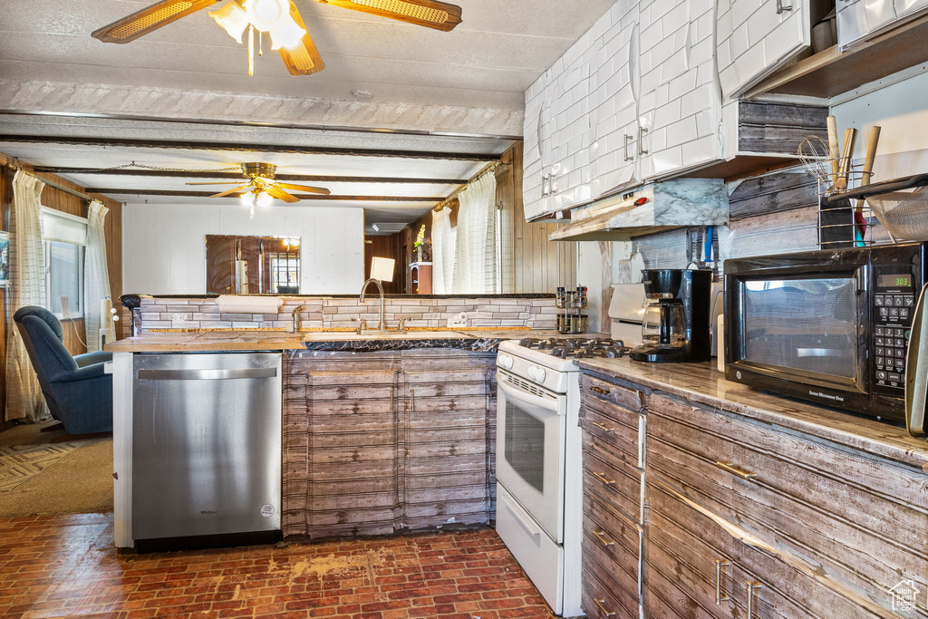 Kitchen featuring dishwasher, white range with gas cooktop, a ceiling fan, and brick patterned floors