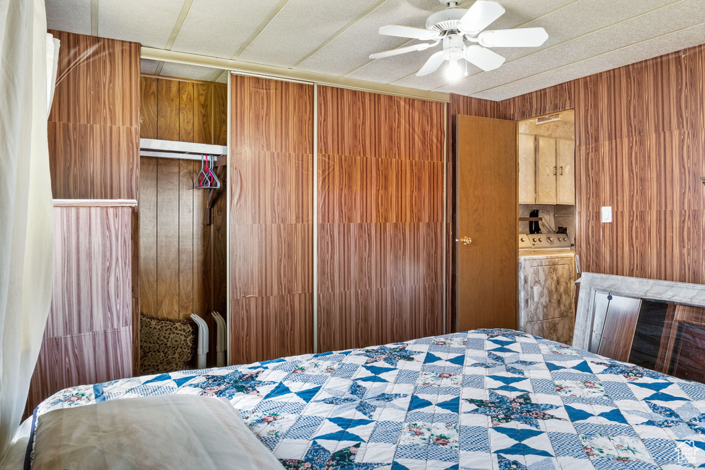 Bedroom featuring a closet, wooden walls, and ceiling fan