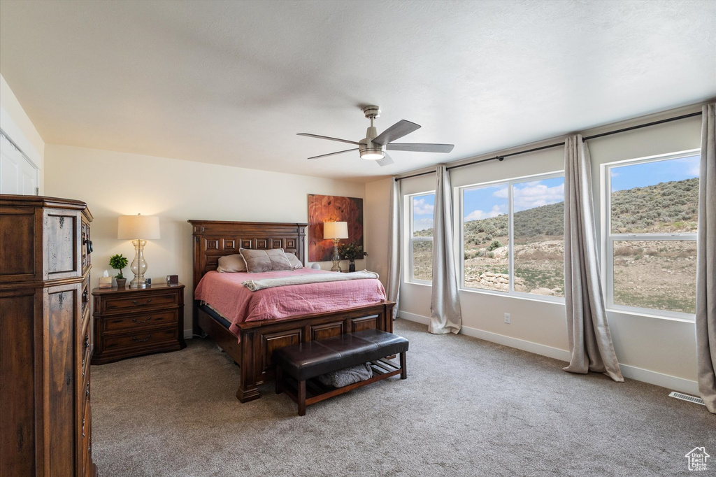 Bedroom with light carpet and a ceiling fan