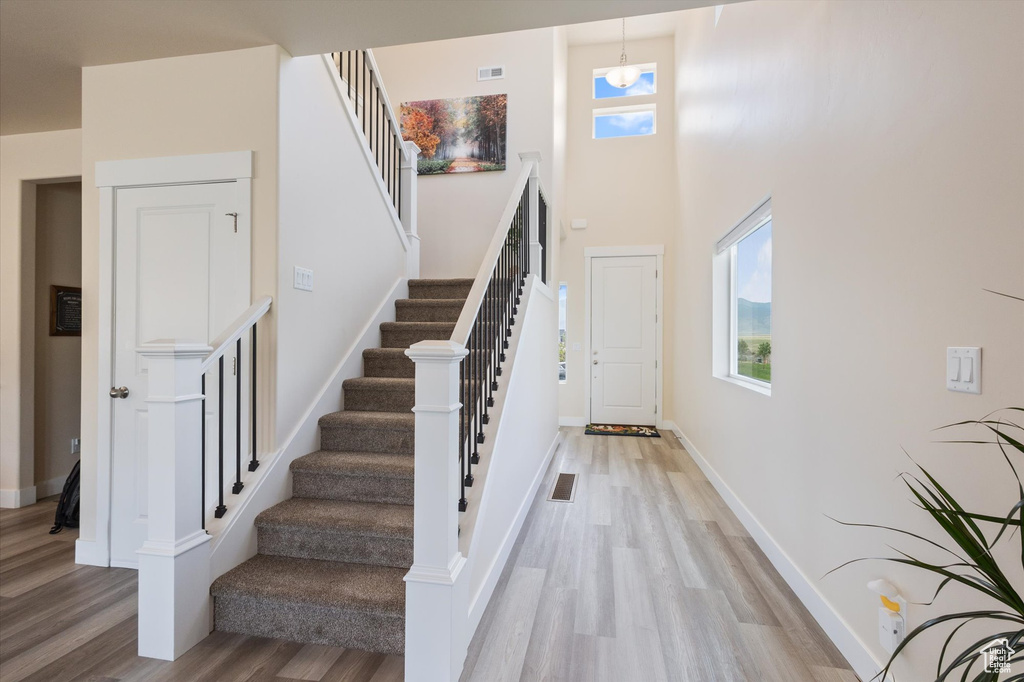 Stairway featuring wood finished floors and a high ceiling