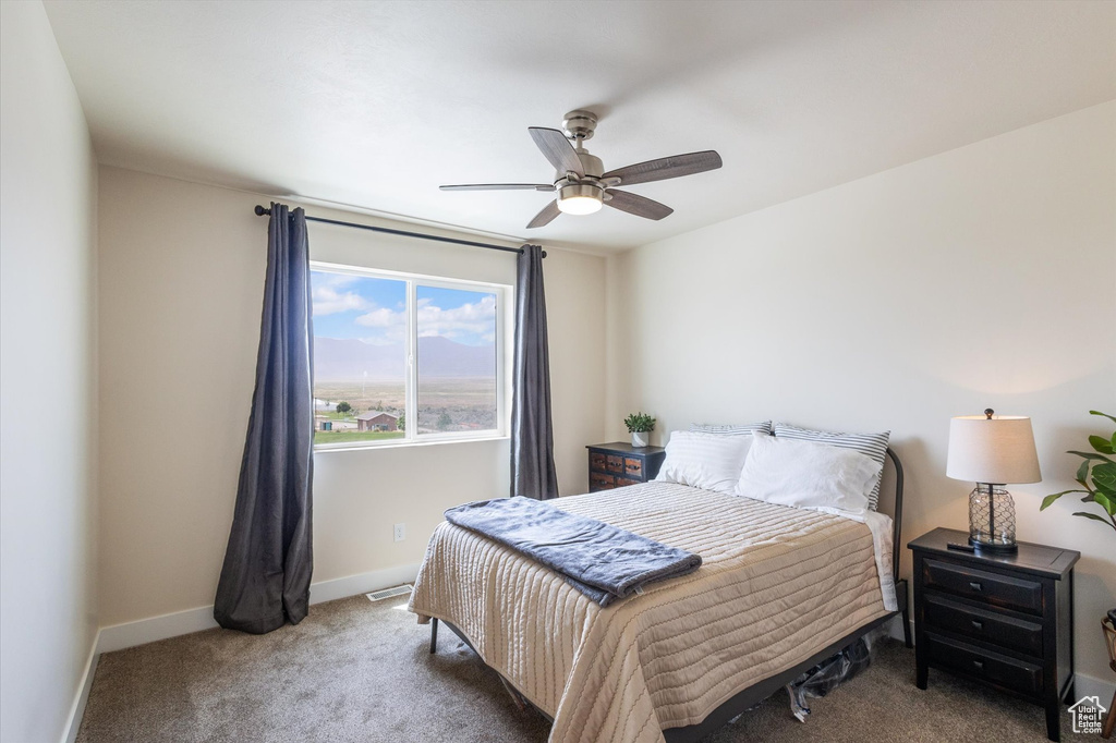 Carpeted bedroom featuring baseboards and a ceiling fan