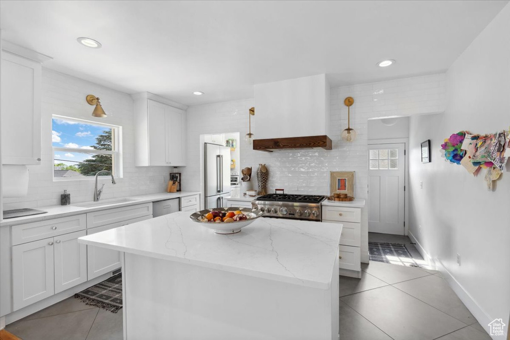 Kitchen featuring stainless steel appliances, light tile patterned floors, decorative backsplash, healthy amount of natural light, and recessed lighting