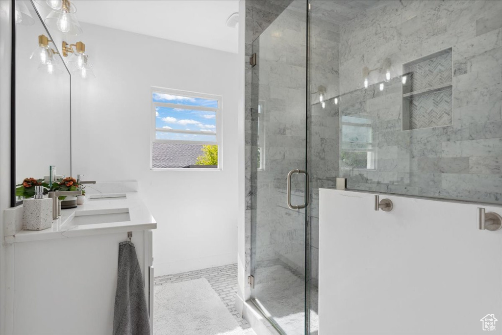Full bath featuring a shower stall and double vanity