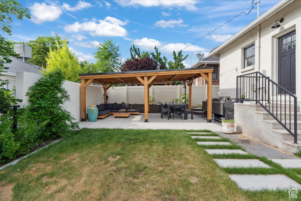 Fenced backyard with an outdoor hangout area, a patio, and a gazebo