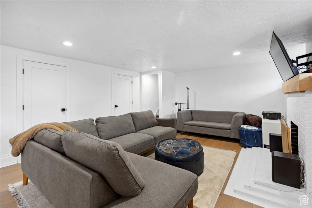 Living area featuring wood finished floors, a fireplace, and recessed lighting