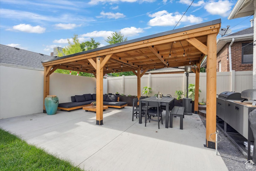 Fenced backyard featuring a gazebo, outdoor dining space, a patio, and an outdoor living space