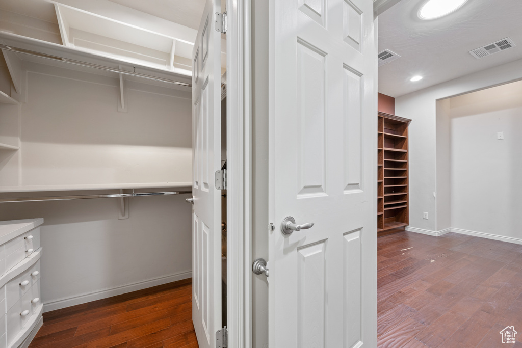 Spacious closet with dark wood-style floors