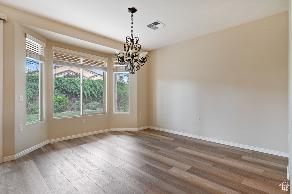 Empty room with a chandelier and wood finished floors