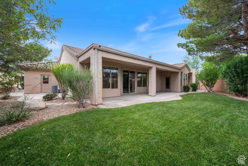 Rear view of house featuring stucco siding, a patio area, and a tile roof
