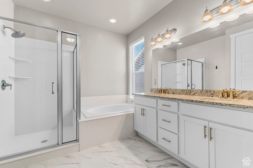 Bathroom featuring a shower stall, double vanity, a bath, marble finish flooring, and recessed lighting
