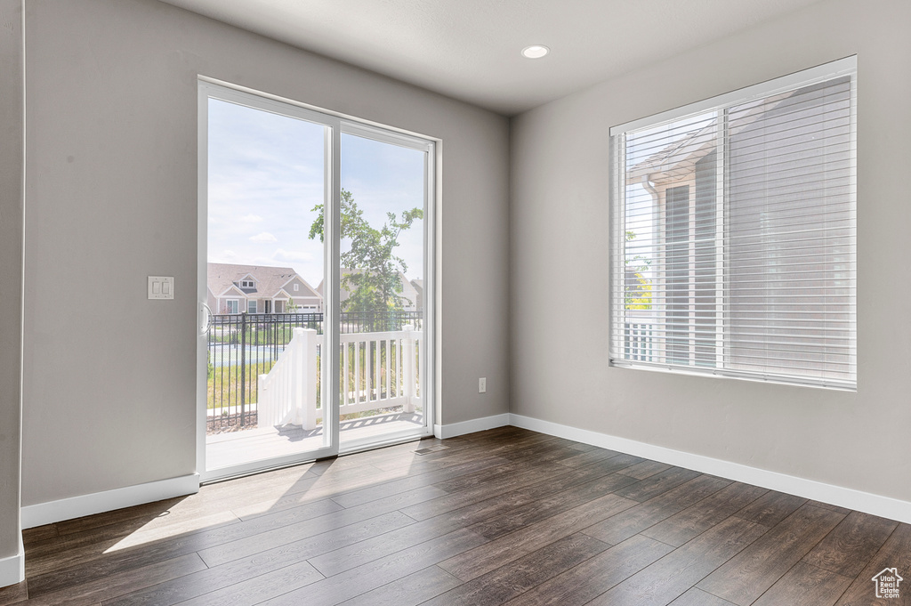 Empty room featuring plenty of natural light, dark wood-style floors, and recessed lighting
